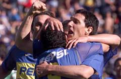 Carlos Tevez omfavnes etter et mål for Boca. Carlos Tevez omfavnes etter et mål for Boca.