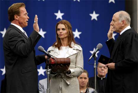Arnold Schwarzenegger vart teken i eid som ny guvernør i California i kveld. I midten kona Maria Schriver. (Reuters-foto)