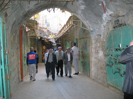 I denne palestinske handlegata i Hebron er neste alle butikker stengt. Jødiske bosetter kaster stein og søppel som er spent over gata til beskyttelse.