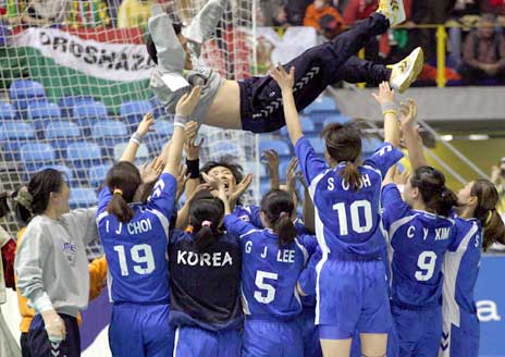 De sør-koreanske spillerne kastet treneren i været etter seieren. (Foto: AP/Scanpix)