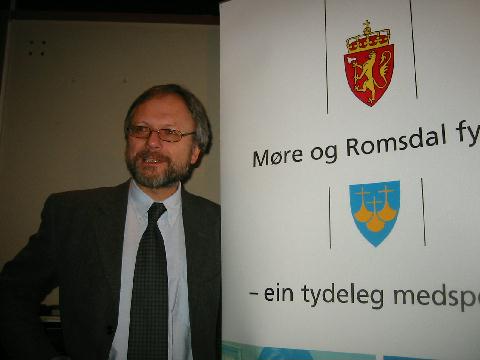 Fylkesdirektør Ottar Brage Guttelvik ved den nye logoen for Møre og Romsdal fylke. Foto: Gunnar Sandvik