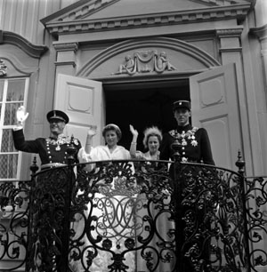 Prinsessene Ragnhild og Astrid vinker til folket fra Stiftsgården i Trondheim etter signingen av kong Olav i Nidarosdomen i juni 1958. Kong Olav står til venstre, mens kronprins Harald står til høyre. (Arkivfoto: Aktuell/Scanpix)