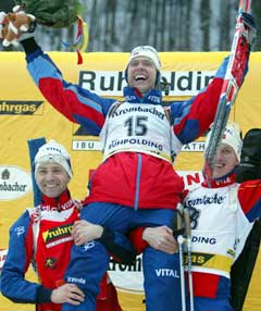 Halvard Hanevold løftes på gullstol av Ole Einar Bjørndalen og Lars Berger. (Foto: Reuters/Scanpix)