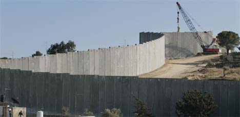 To palestinere beskuer israelernes bygging av den enorme muren på Vestbredden. (Foto: AP/Scanpix)