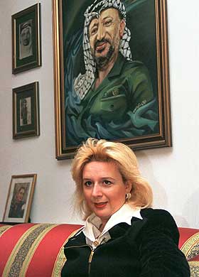 Suha Arafat under et portrett av sin mann, palestinernes president Yasir Arafat. Foto: Adel Hana, AP)