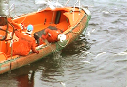 Kystvakta plukker opp død fisk som er dumpet i havet Foto: NRK Brennpunkt