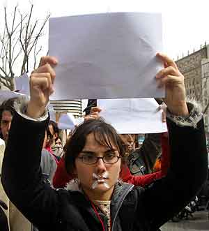En kvinne i Barcelona holder opp et blankt ark som symboliserer fred, under den stille protesten i Spania i dag. Foto: Albert Gea, Reuters