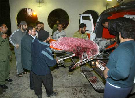 Båren med levningene av sjeik Yassin blir båret inn i en ambulanse. (Foto: AFP/Scanpix)