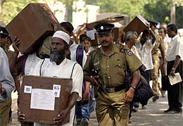 Væpnet politi følger menn med stemmeurner i hovedstaden Colombo (Scanpix/Reuters)