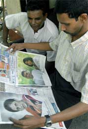 På et hjørne i Colombo studeres morgenavisen med bilder av de to rivalene (Scanpix/AFP)