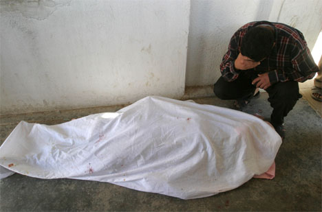 SØRGER OVER SINE DØDE: En mann gråter over kroppen av sin døde tenåringsdatter i Falluja. (Foto: Reuters/Scanpix)