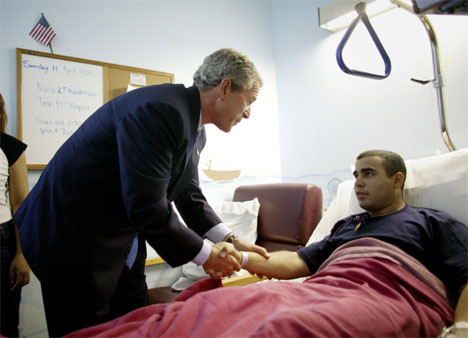 President George W. Bush i mte med srede fra Irak-krigen. Her hilser han p Ismael Torres p et sykehus i Texas. (Foto: Reuters/Scanpix)