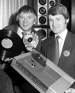 1983: Til høyre Svein Hilmarsen i Philips med den nye compact disc-spilleren, og Mikkel Aas fra Polygram med ny og "gammel" plate. Foto: NTB-arkiv/SCANPIX 
