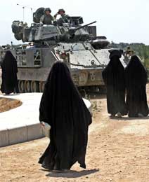 Irakiske kvinner betrakter en Bradley stridsvogn (Scanpix/Reuters)