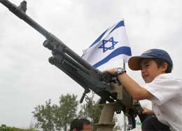 En israelsk gutt på Gazastripen leker med et maskingevær i protest mot den planlagte tilbaketrekkingen (Scanpix/Reuters)