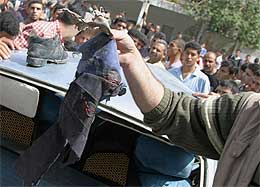 En palestiner viser fram blodige rester av klær etter angrepet (Scanpix/AFP)