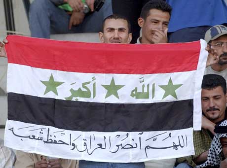 En irakisk supporter holder opp ett flagg der det står 