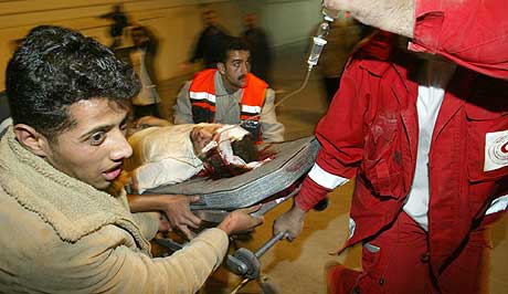 OVERLEVDE: Flere palestinere ble drept av raketter tirsdag morgen. Her fraktes en av de sårede til sykehuset. (Foto: AP/Kevin Frayer)