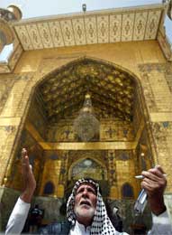 Gammel mann med hellig bok ber foran Imam Ali-moskeen (Scanpix/Reuters)