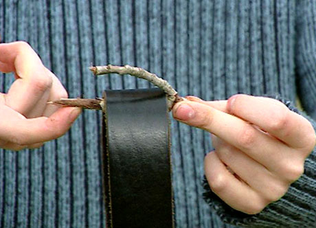 Sett skinnbeltet inni hakket på kvisten og plasser enden av kvisten på fingeren. (Foto: NRK)