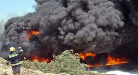 En irakisk brannmann i aksjon ved en oljebrann 27. juni i r. (Foto: Scanpix/Reuters)