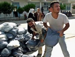 Palestinere bærer sekker med mat som ble distribuert av FN til innbyggerne i den isolerte byen Beit Hanun. Foto: AP/Scanpix. Palestinere bærer sekker med mat som ble distribuert av FN til innbyggerne i den isolerte byen Beit Hanun. Foto: AP/Scanpix.