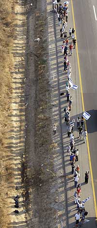 PROTESTERER: Over 100.000 israelere dannet en kjede av mennesker for å protestere mot planen. (Foto: Oded Balilty/AP)