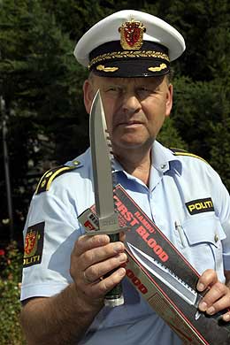 Overbetjent Finn Abrahamsen viser fram drapsvåpenet. (Scanpix-foto)