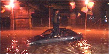 Denne bilen begynte plutselig å flyte rundt av seg selv da føreren forsøkte å krysse Holmen. Det eneste tørre stedet for mannen var på taket av bilen. (Foto: Harald Inderhaug)