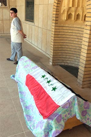 Omar Bashar står ved sin døde fars kiste. Han var politimann i Bagdad, men ble drept av en bilbombe. (Foto: AP/Scanpix)