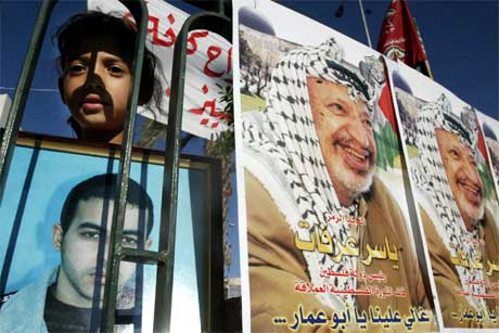 Ei palestinsk jente holder opp et bilde av sin fengslede bror under en demonstrasjon. Andre bærer bilde av Arafat (Scanpix/Reuters) Ei palestinsk jente holder opp et bilde av sin fengslede bror under en demonstrasjon. Andre bærer bilde av Arafat (Scanpix/Reuters)