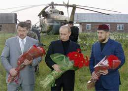 Putin og Alu Alkhanov (t.v.) ved Kadyrovs grav. Til høyre Kadyrovs sønn Ramzan (Scanpix/AP)