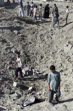 En irakisk gutt i krateret etter det amerikanske bombeangrepet i Falluja i dag. (Foto: Reuters/Scanpix)