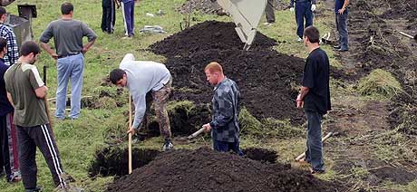 BEGRAVER SINE DØDE: Innbyggere i Beslan må klargjøre mange graver etter gisseldramaet. Søndag ble drøyt 20 ofre stedt til hvile. (Foto: Musa Sadulayev/AP)