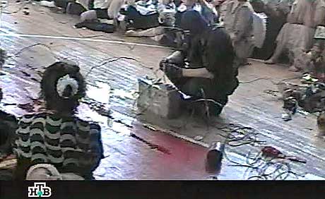 BESLAN: Dette bildet visen en av gisseltakerne som kobler sammen flere ledninger inne i gymsalen ved skolen i Beslan. (Foto: NTV/AFP) BESLAN: Dette bildet visen en av gisseltakerne som kobler sammen flere ledninger inne i gymsalen ved skolen i Beslan. (Foto: NTV/AFP)