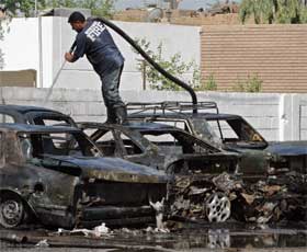 KRAFTIG BOMBE: Irakisk brannvesen slukker branner i flere biler som ble totalvrak i eksplosjonen. (Foto:REUTERS/Aladin Abdel Naby)