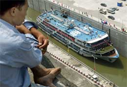 En arbeider på bredden ser ned på det første prøveskipet som går gjennom kanalen knyttet til anlegget (Scanpix/AFP)