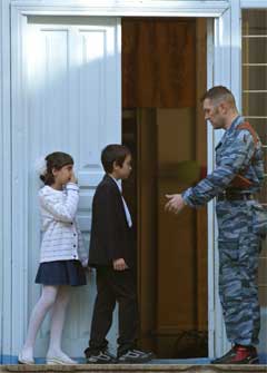 En politimann i Nord-Ossetia lar barna få se sin nye skole, noen dager før skolestart.(Foto:Scanpix)