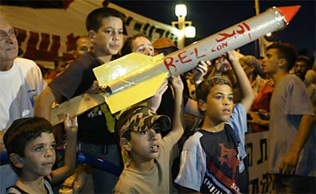 Israelske barn med en etterlikning av en hjemmelaget palestinsk Qassam-rakett. I dag ble en israelsk gutt drept av en virkelig Qassam (Scanpix/AP)
