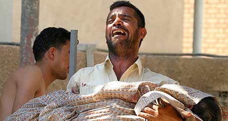 FORTVILTE FORELDRE: Mange av de drepte er barn. Her brer en far bort sin dde snn. (Foto: Ceerwan Aziz/Reuters)