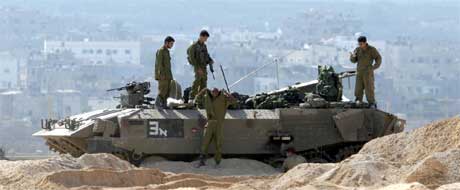 Israelske soldater vokter husene til israelske bosettere på Gazastripen. Flyktningleiren Jabalaya i bakgrunnen.(Arkivfoto: Scanpix) Israelske soldater vokter husene til israelske bosettere på Gazastripen. Flyktningleiren Jabalaya i bakgrunnen.(Arkivfoto: Scanpix)