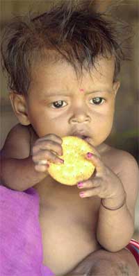 Et lite barn spiser kjeks i en landsby som ble rammet av sult like ved Calcutta i India i sommer. (Foto: Scanpix / AP / Bikas Das)