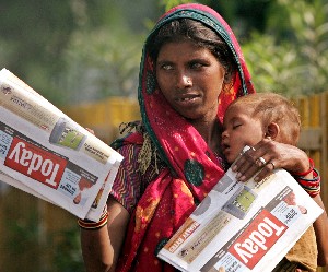 En mor i indiske New Delhi selger aviser i forsøk på å livnære seg og sitt barn. (Foto: Reuters/Scanpix)