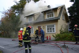 Brannen i loftsetasjen på dette huset førte til at riksvei 61 måtte stenges ved Eidså i formiddag. (Foto: Sigve Slagnes)