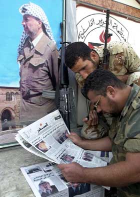 To palestinere leser avisreportasjen om helsetilstaden til Yasser Arafat i Hein el-Hilweh i Sør-Libanon. (Foto: Mohammed Zaatari / AP / Scanpix)