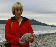 Torill Helene Molnes lagar kunst av stein frå si eiga strand. Foto: NRK.