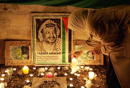 En kvinne tenner et lys for Yasir Arafat utenfor det franske militærsykehuset sør for Paris. (Foto: P.Andrieu, AFP)