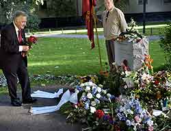 Anna Lindhs enkemann, Bo Holmberg, legger blomster på graven 11.september i år, ett år etter drapet. Foto: Christan Oernberg, AFP