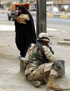 En kvinne i Bagdad passerer en kampklar amerikansk soldat. (Foto: AP/Scanpix)