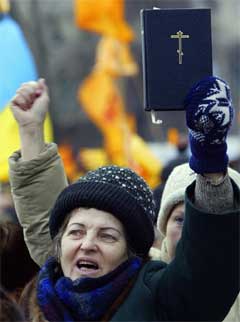 Kvinnen vifter med Bibelen under demonstrasjonen i Kiev.(Foto:Scanpix)